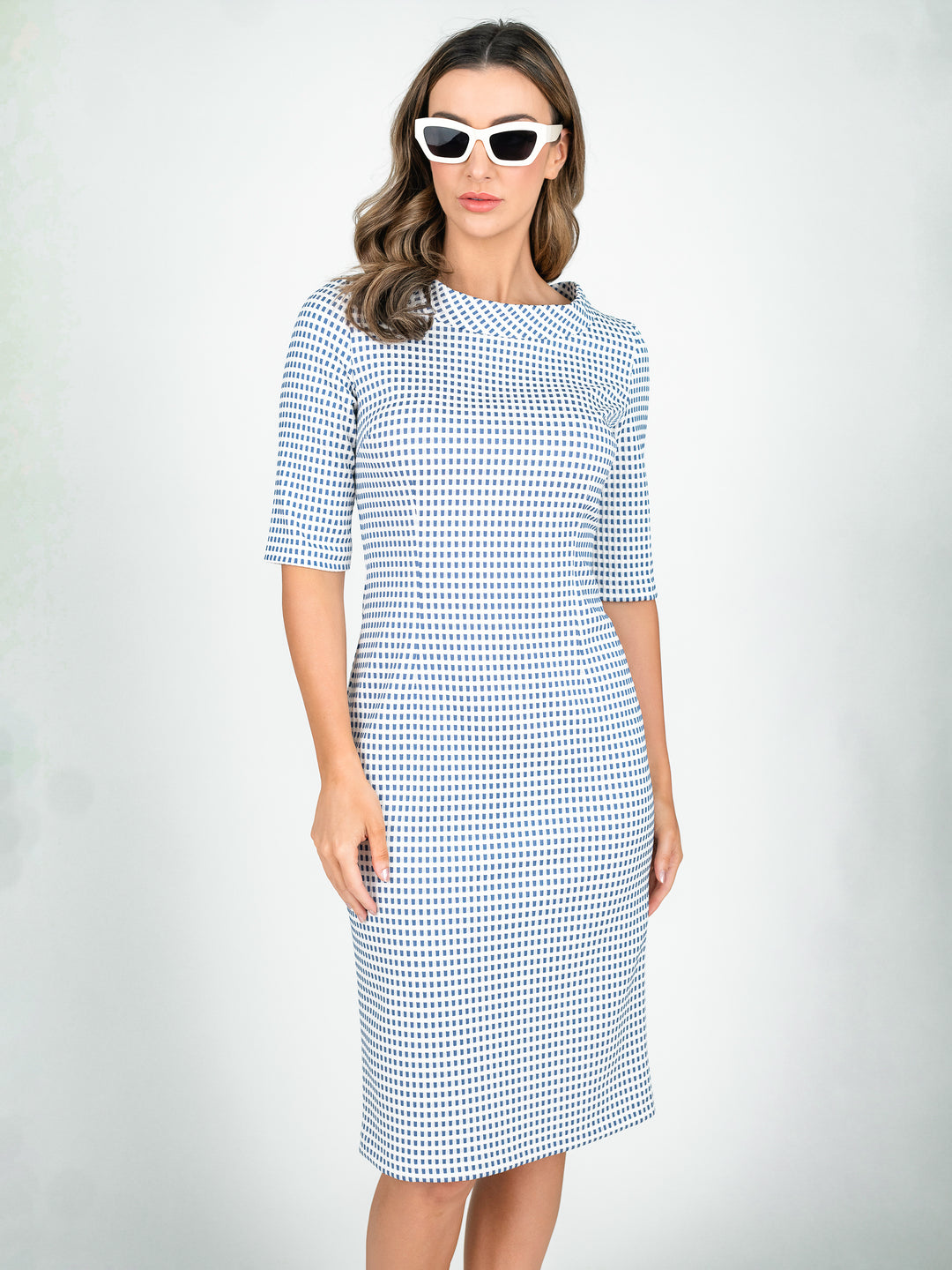 Blue and ivory women's 3/4 sleeve knee length tailored dress with boat neck standing collar and white sunglasses